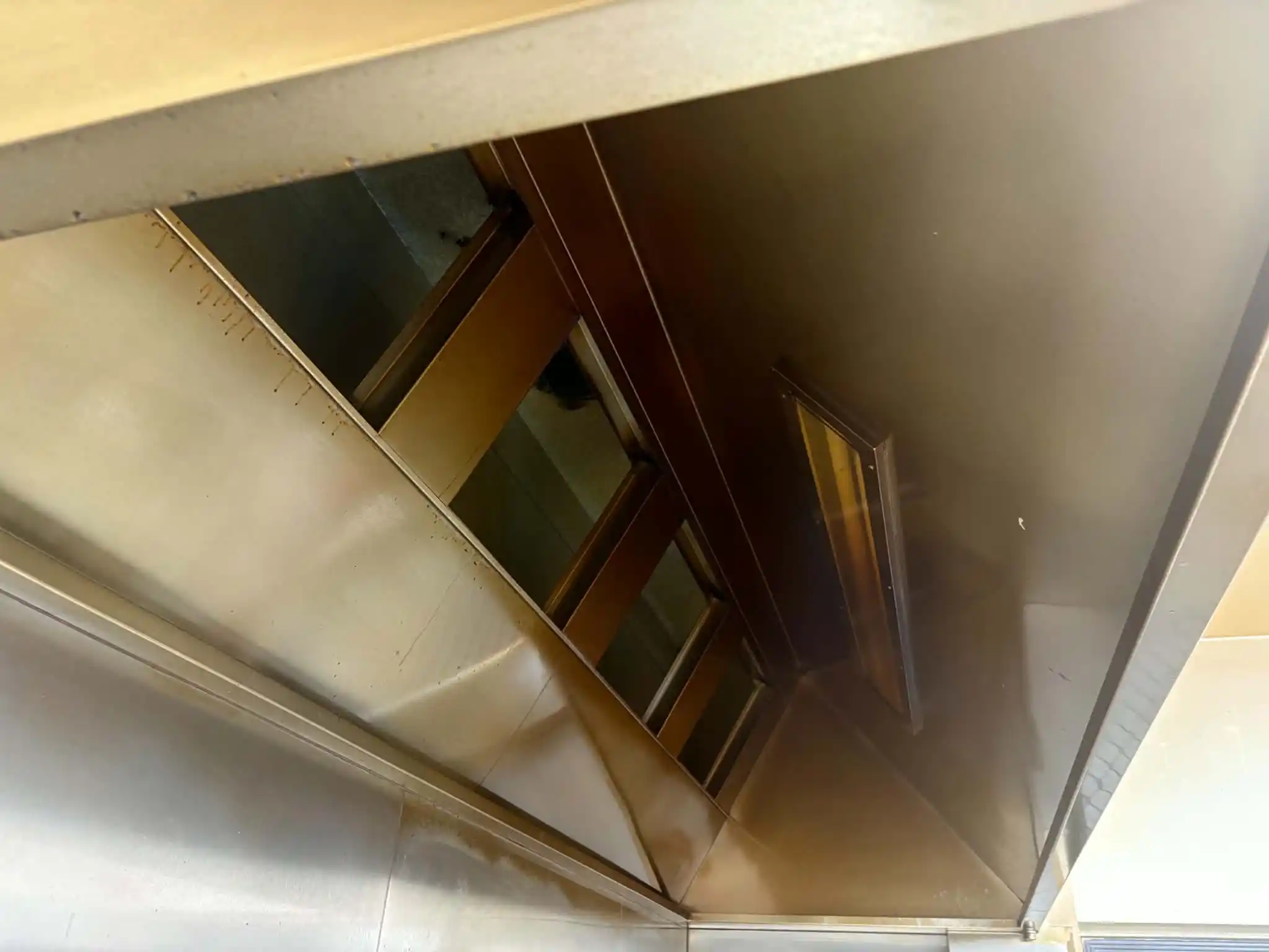 Grease-stained commercial kitchen canopy before cleaning